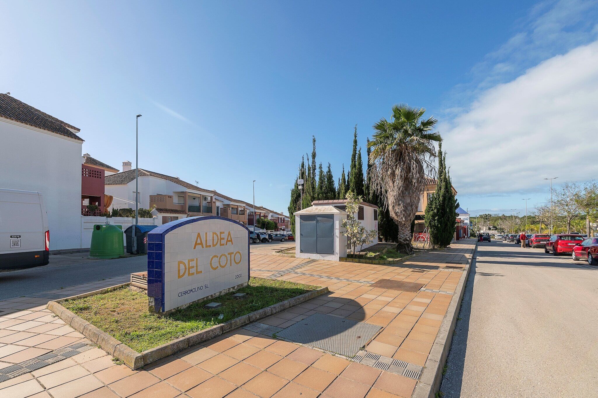 A residential area with a sign for "Aldea Del Coto" and a small utility shed.