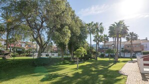 A well-maintained grassy area with trees and a paved walkway.