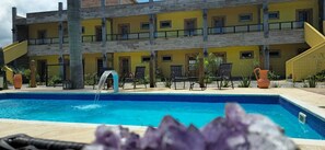 A multi-story building with a swimming pool in the foreground. - Hotel Barra da Ferrugem Eco Village (Garopaba)