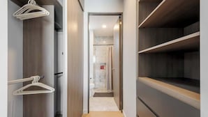 Un pasillo estrecho con suelo de madera y una puerta que da a un baño.