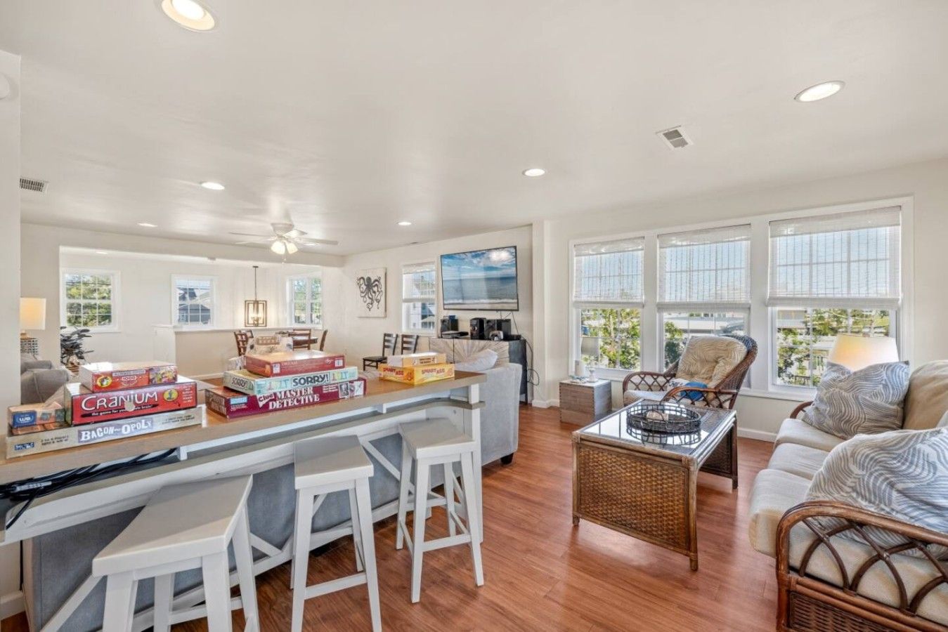 A spacious living area with a kitchen counter, bar stools, and a dining table.
