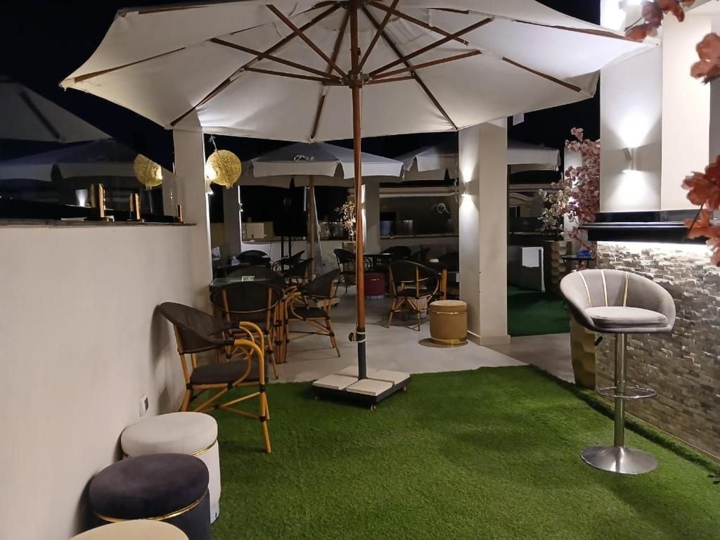 An outdoor seating area with a bar, artificial grass, and wicker furniture.