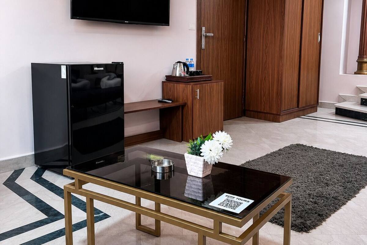 A modern living room with a flat-screen TV, a coffee table, a sofa, and a wooden wardrobe.