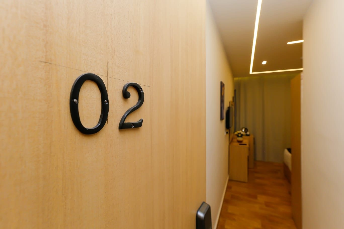 A hallway with a wooden wall and a number '02' sign.