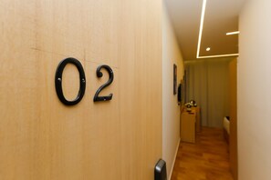 A hallway with a wooden wall and a number '02' sign. - Sky Hotel Pyramids View INN (Giza)