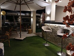 A modern interior with a bar area, seating, and a stone wall. - Sky Hotel Pyramids View INN (Giza)