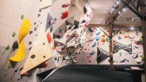 A climbing gym with various climbing walls and wooden beams. - The Wakefield Grand (Wakefield)