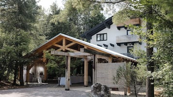 A modern house with a wooden deck and a covered patio area.