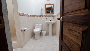 Ein Badezimmer mit Toilette, Waschbecken und Spiegel.