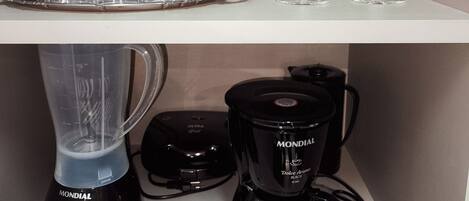 Ein Küchenregal mit verschiedenen Gläsern und einer Kaffeemaschine.