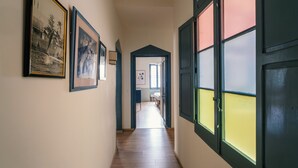 Ein Flur mit gerahmten Bildern an der Wand, Holzboden und einer Tür mit Fenster.