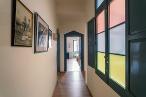 A hallway with framed pictures on the wall, a wooden floor, and a door with a window. - Luxury & stylish 4bedroom, Valletta centre LDEM1-1 (Valletta)