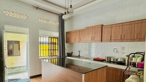 Una cocina moderna con armarios de madera, una isla central y un techo con molduras decorativas.