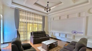 Un salón espacioso con un conjunto de sofás modernos, una mesa de centro y una araña.