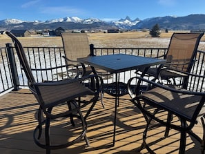 A deck with a table and chairs, overlooking a snowy mountain landscape. - 1BR Teton View Getaway w/ Hot Tub near Skiing & Nat’l Parks (Driggs)