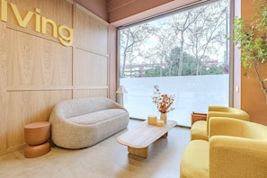 Un salon moderne avec un canapé, une table basse et un fauteuil jaune.