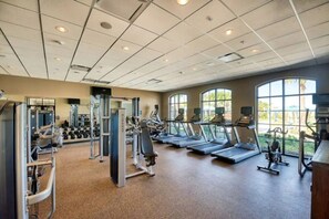 Un gimnasio con cintas de correr, máquinas de pesas y mancuernas.