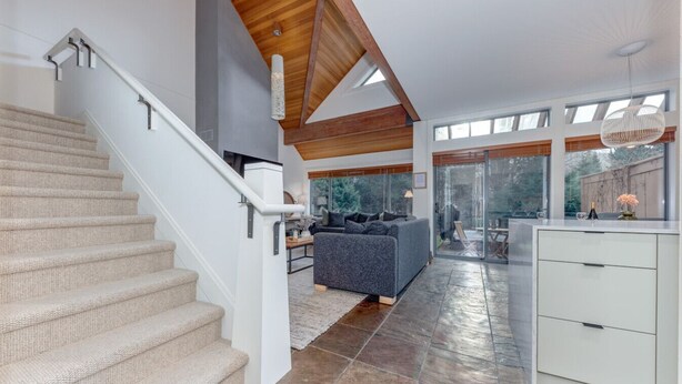 A spacious living area with a staircase, a grey sofa, and a kitchen area with a white cabinet. - 3BD/3BA Village Townhome/Hot Tub (Whistler)