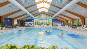 An indoor swimming pool with a high ceiling, wooden beams, and large windows. - Bungalow in North Holland Near the Beach (Sint Maartensvlotbrug)
