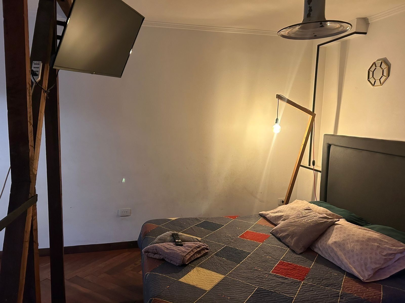 Ein Schlafzimmer mit einem Bett, einer Stehlampe und einer Wandleuchte.