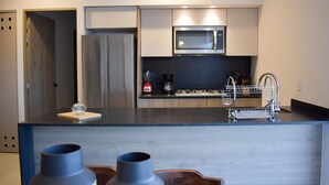 Eine moderne Küche mit Edelstahlgeräten, einer Mikrowelle und einem eingebauten Backofen.