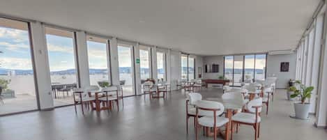 Un espacio interior amplio con diversas opciones de asientos, ventanas grandes y vistas al exterior.