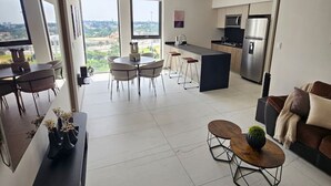 Un appartement moderne comprenant un coin repas, une cuisine et un salon.