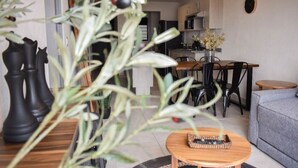 Ein modernes Wohnzimmer mit Essbereich, ausgestattet mit einer Couch, einem Couchtisch und einem Esstisch mit Stühlen.