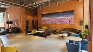 A spacious lounge area with brick walls, a large abstract art piece, and modern furniture. - New apartment with incredible view in YU Country 1804 (Guadalajara)