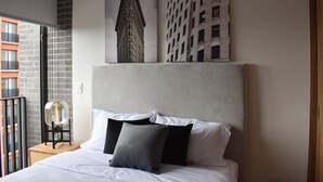 A hotel room with a bed, a nightstand, a chair, and two wall-mounted pictures of buildings. - New apartment with incredible view in YU Country 1804 (Guadalajara)