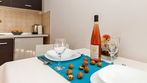 A dining table with a wine bottle, glasses, and walnuts. - Beachfront Escape in Rovinj - Sea Studio (Rovinj)
