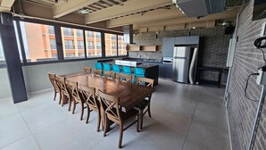 A modern kitchen with a dining area, large windows, and a view of buildings outside. - New Penthouse with the best view of GDL 2503B (Guadalajara)