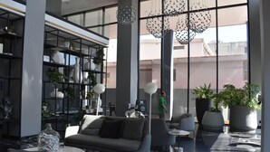Un vestíbulo moderno con sofá, mesa de centro y plantas en macetas.