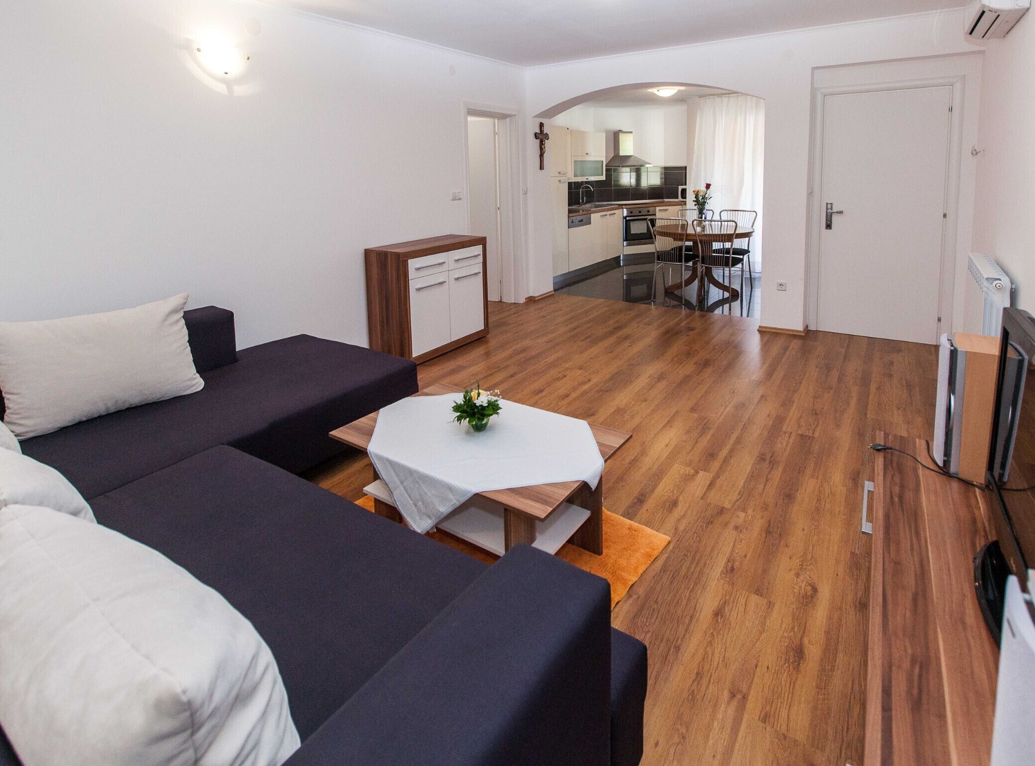 Una sala moderna con un conjunto de sofás, una mesa de centro y un comedor con mesa y sillas.