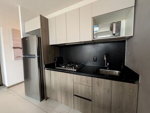A modern kitchen with a stainless steel refrigerator, a gas stove, and a microwave above the counter. - Amazing new apartment near Andares 1209B (Zapopan)