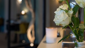 A white vase with white roses on a counter. - Hotel Restaurant Le Vinois (Caillac)
