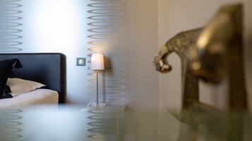 Et hotelværelse med en seng, en lampe og en dekorativ vægdekoration.