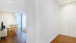 A modern, minimalist room with a wooden floor, white walls, and a large closet. - Bombarda Patio Oasis by LovelyStay (Porto)