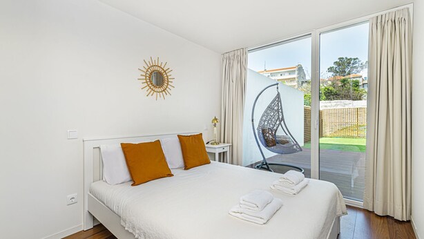 A hotel room with a bed, a hanging chair, a sun decoration, and a view of the outside. - Bombarda Patio Oasis by LovelyStay (Porto)