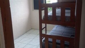 Une chambre avec un lit superposé, une fenêtre donnant sur un beau paysage et un climatiseur fixé au mur.