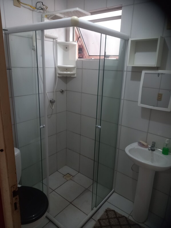 Een douche, handdoeken, zeep, toiletpapier