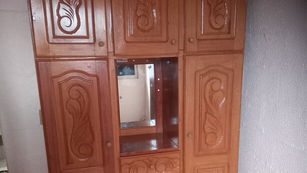 Une armoire en bois ornée de sculptures complexes et dotée d’un miroir.