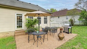 Eine Terrasse mit Gartenmöbeln, einem Grill und einer Zierurne.
