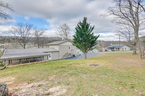 A residential area with a large house, a covered porch, and a tall evergreen tree. - Apt w/ Lake Views - Day Trip to Virginia Tech! (Radford)
