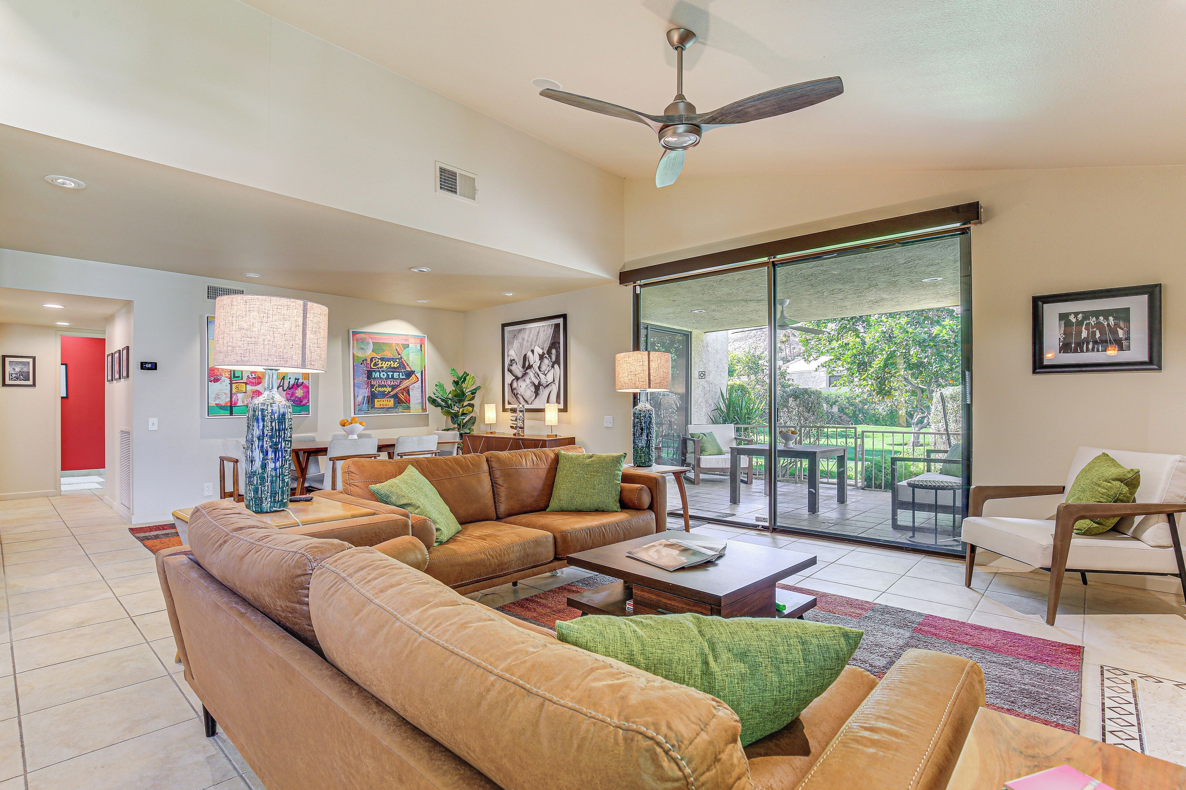 A spacious living room with a large sectional sofa, a coffee table, and a dining area with a table and chairs.