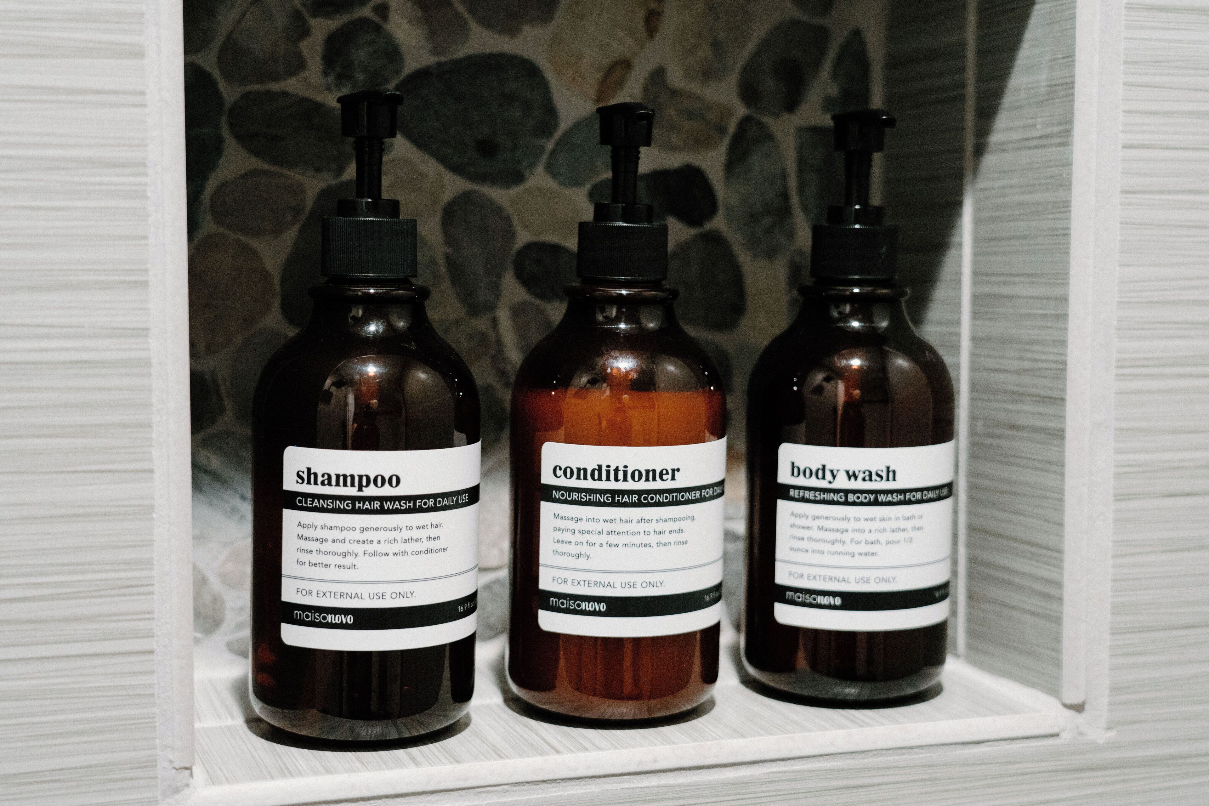 Three bottles of hair care products on a shelf.