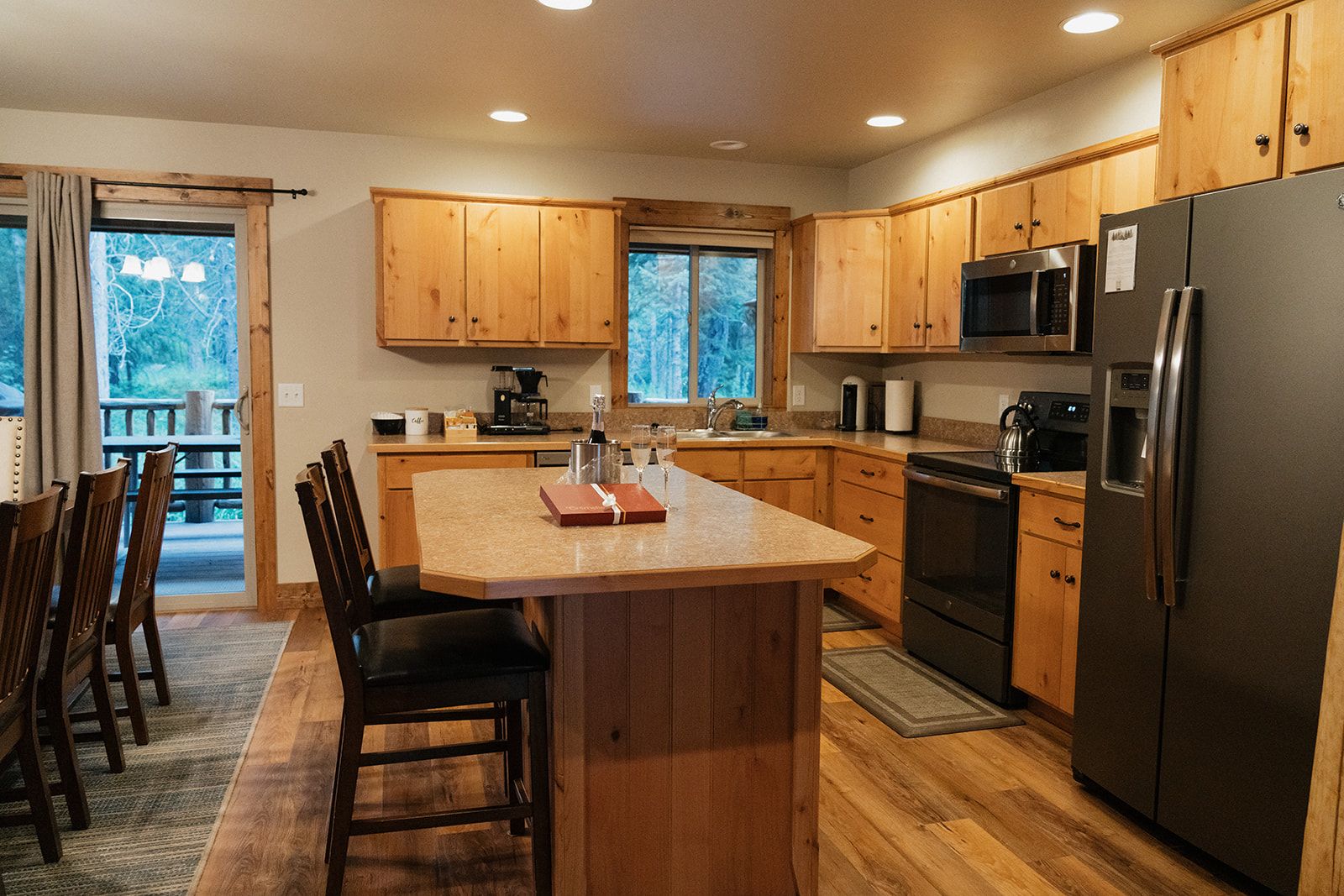 A kitchen with wooden cabinets, a central island, a refrigerator, and a microwave.