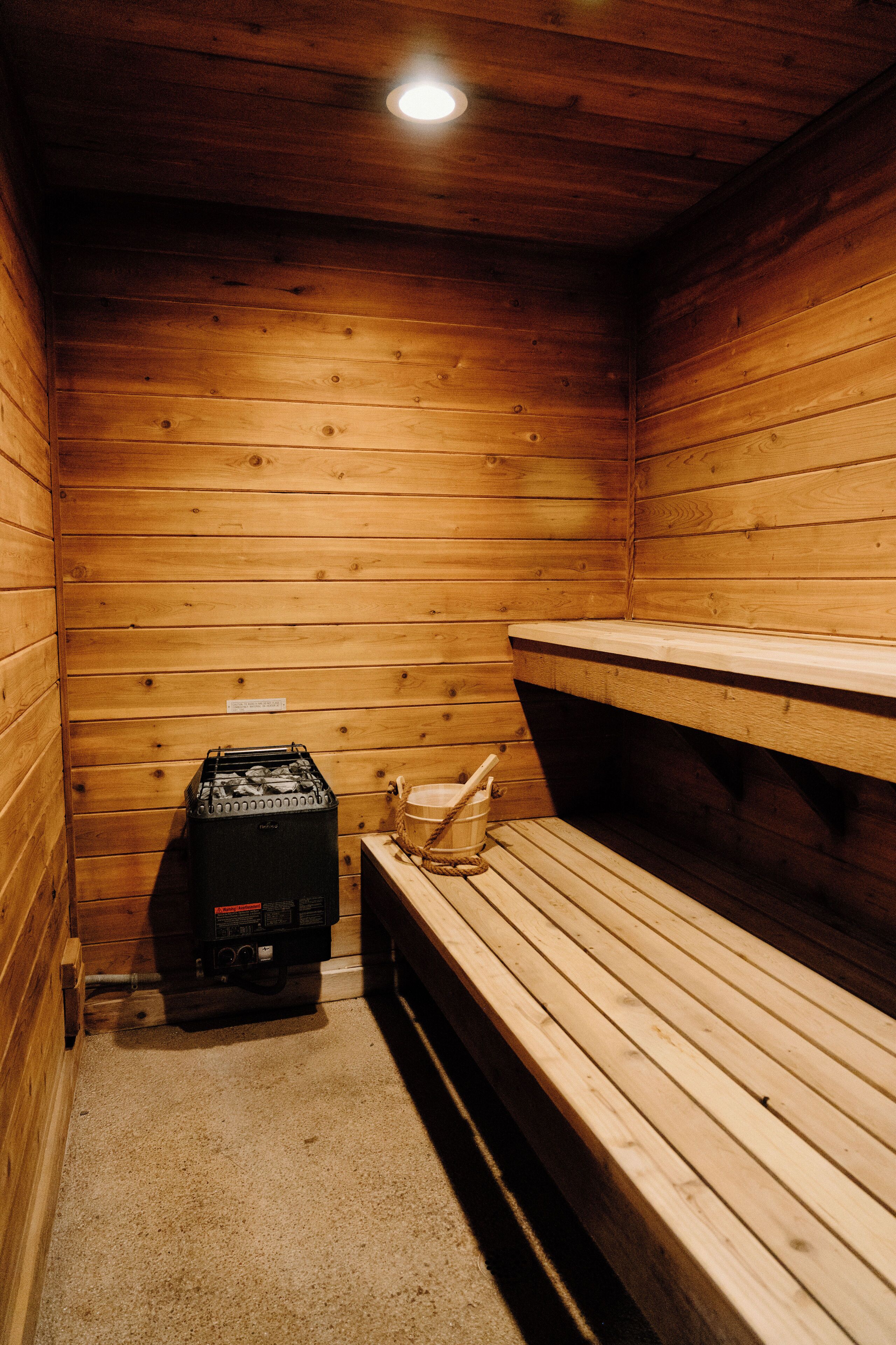 Un sauna en bois, doté de bancs et d’un système de chauffage.