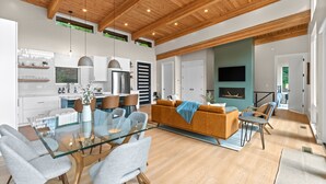 A spacious living area with a glass dining table, modern furniture, and a wooden ceiling. - Mtn View, 3 Miles to DT AVL, King Bed, Fire Pit (Asheville)