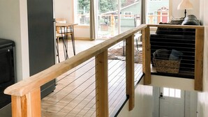 Een ruime keuken met een houten terras, grote ramen en uitzicht op de achtertuin.